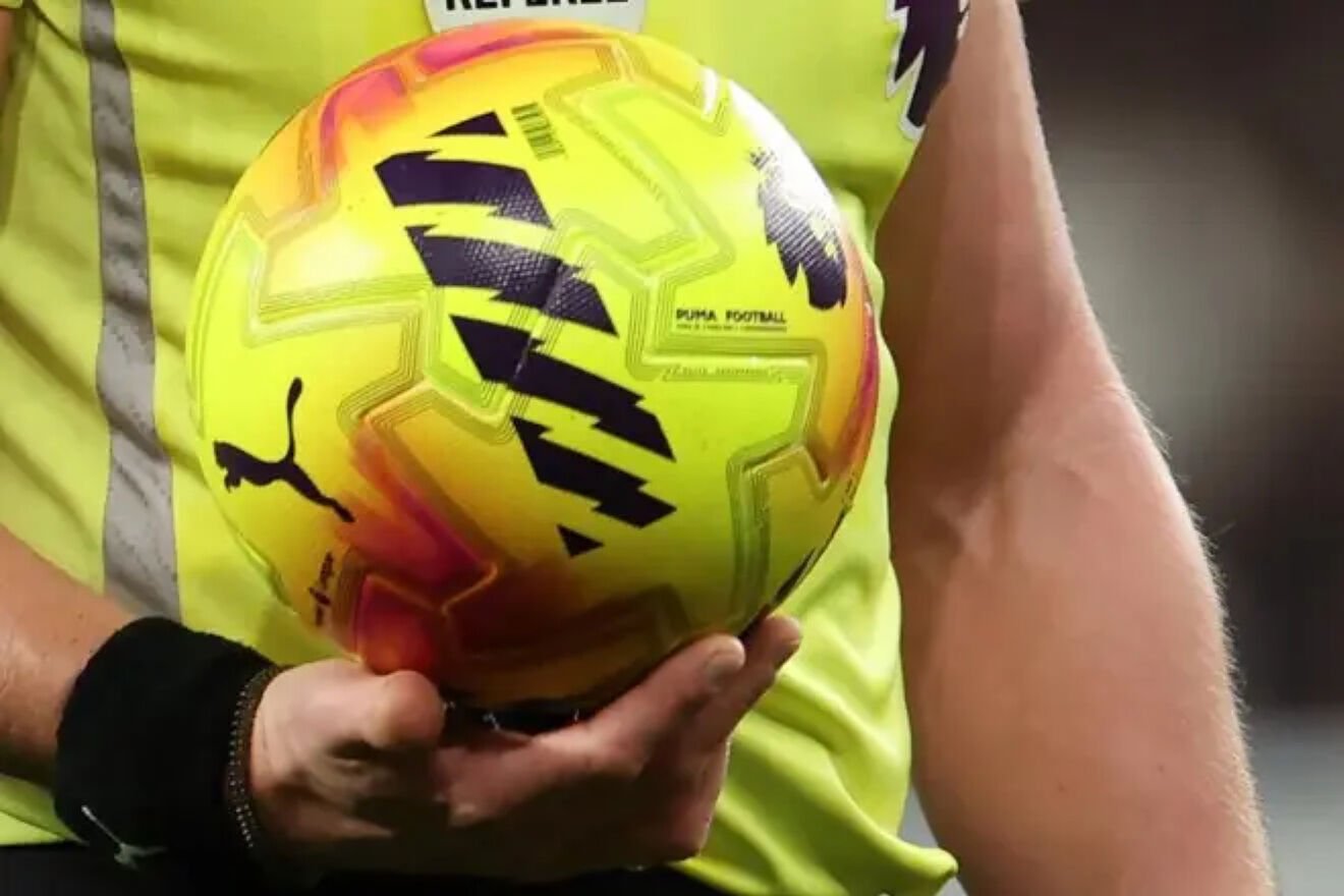 A referee holds the Premier League ball.